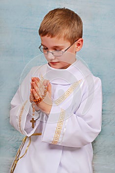 Boy going to the first holy communion with a rosary
