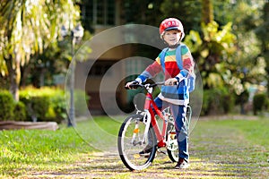 Boy going to school on bike. Kids ride bicycle