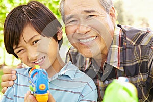 Boy and grandfather with water pistols