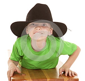 Boy green shirt cowboy hat lay looking