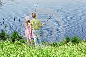 Boy and his sister fish in pond