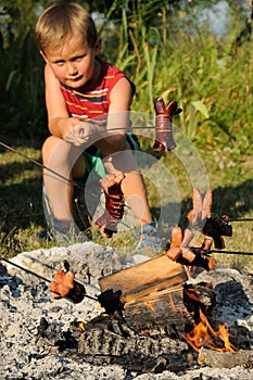 Boy grilling sausages