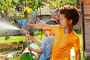 Boy with group of children shoot water pistol