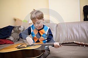Boy with guitar sitting on couch