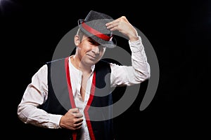 Boy or guy in national ethnic clothing posing in Studio on black background. Young man with hat in dark room