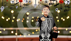 boy in halloween costume with candies and torch