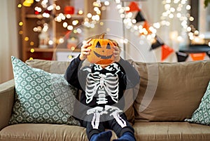 boy in halloween costume with jack-o-lantern