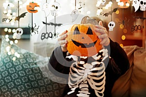 boy in halloween costume with jack-o-lantern