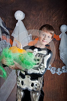 Boy in Halloween costume with orange pumpkin