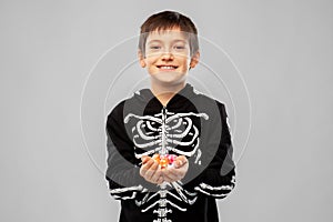 Boy in halloween costume of skeleton with candies