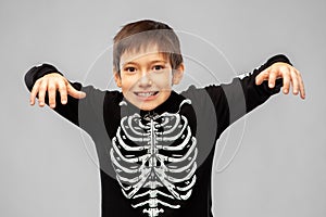 Boy in halloween costume of skeleton frightening