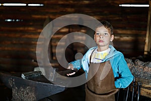 Boy with hammer in forge