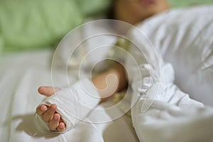 boy hand with saline intravenous, iv or drip on hospital bed