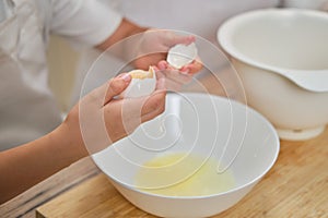 Boy hands separating the egg white from the yolk for the pie