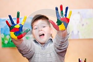 Boy with hands soiled in a paint