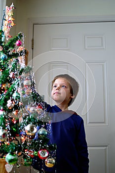 Boy hanging icicles on Christmas Tree decorating