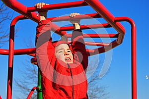 Boy Hanging on Monkey Bars