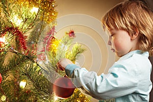 Boy hangs Christmas toy