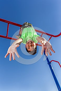 Boy hangs upside down while playing.