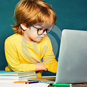 Boy with happy face expression near desk with school supplies. Private school. Teachers day. Ready for school. School