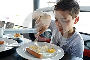 Boy has breakfast in restaurant