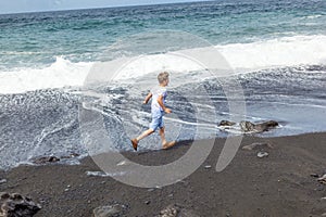 Boy has fun at the black beach