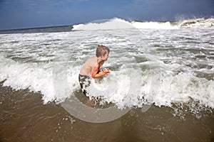 Boy has fun in the breakers of the ocean