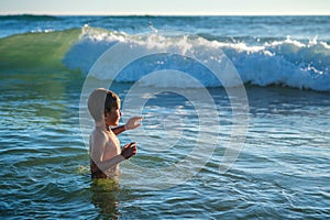 Boy having fun jumping in ocean sea waves photo