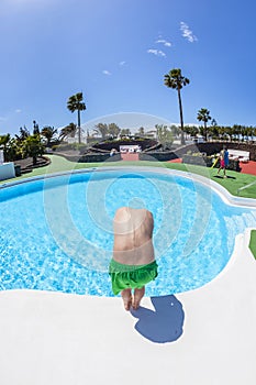 boy has fun jumping in the outdoor pool