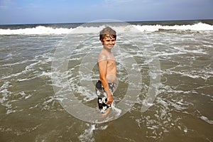 Boy has fun in the stormy beach