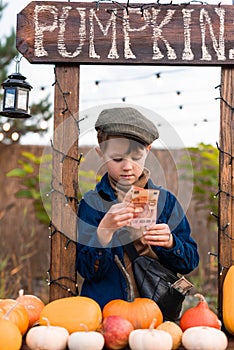 A boy in a hat counts money at a counter at a fair