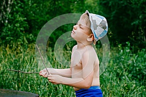 The boy in the hat in the green forest