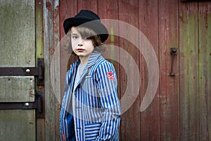 Boy with Hat Leaning Against the Wall