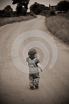 Boy in hat walking down road
