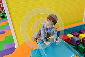 Boy having fun in kids amusement park and indoor play center. Child playing with colorful toys in playground.