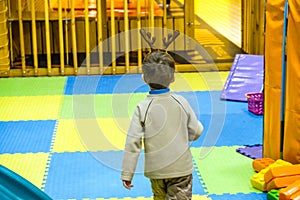 Boy having fun in kids amusement park and indoor play center. Child playing with colorful toys in playground.