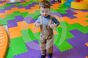 Boy having fun in kids amusement park and indoor play center. Child playing with colorful toys in playground.