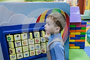 Boy having fun in kids amusement park and indoor play center. Child playing with colorful toys in playground.