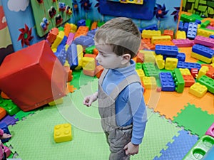 Boy having fun in kids amusement park and indoor play center. Child playing with colorful toys in playground