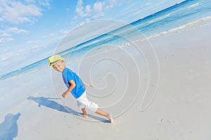 Boy having fun on tropical ocean beach. Kid during family sea vacation.