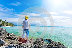 Boy having fun on tropical ocean beach. Kid during family sea vacation.