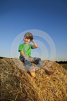 Boy in a haystack in the field