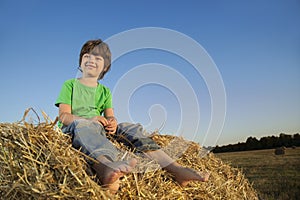 Boy in a haystack in the field