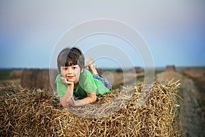 Boy in a haystack in the field