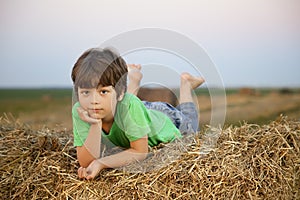 Boy in a haystack in the field