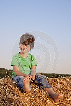 Boy in a haystack in the field