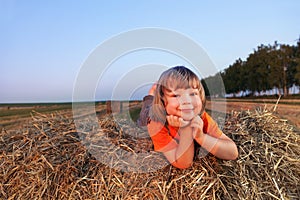 Boy on haystack in the field