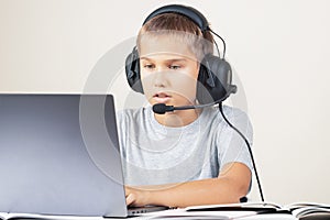 Boy in a headphones with notebook computer. Online learning, remote education at home