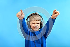 A boy in headphones shows his thumbs forward urging people to dance