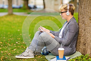 Boy with headphones, tablet pc, books and coffee